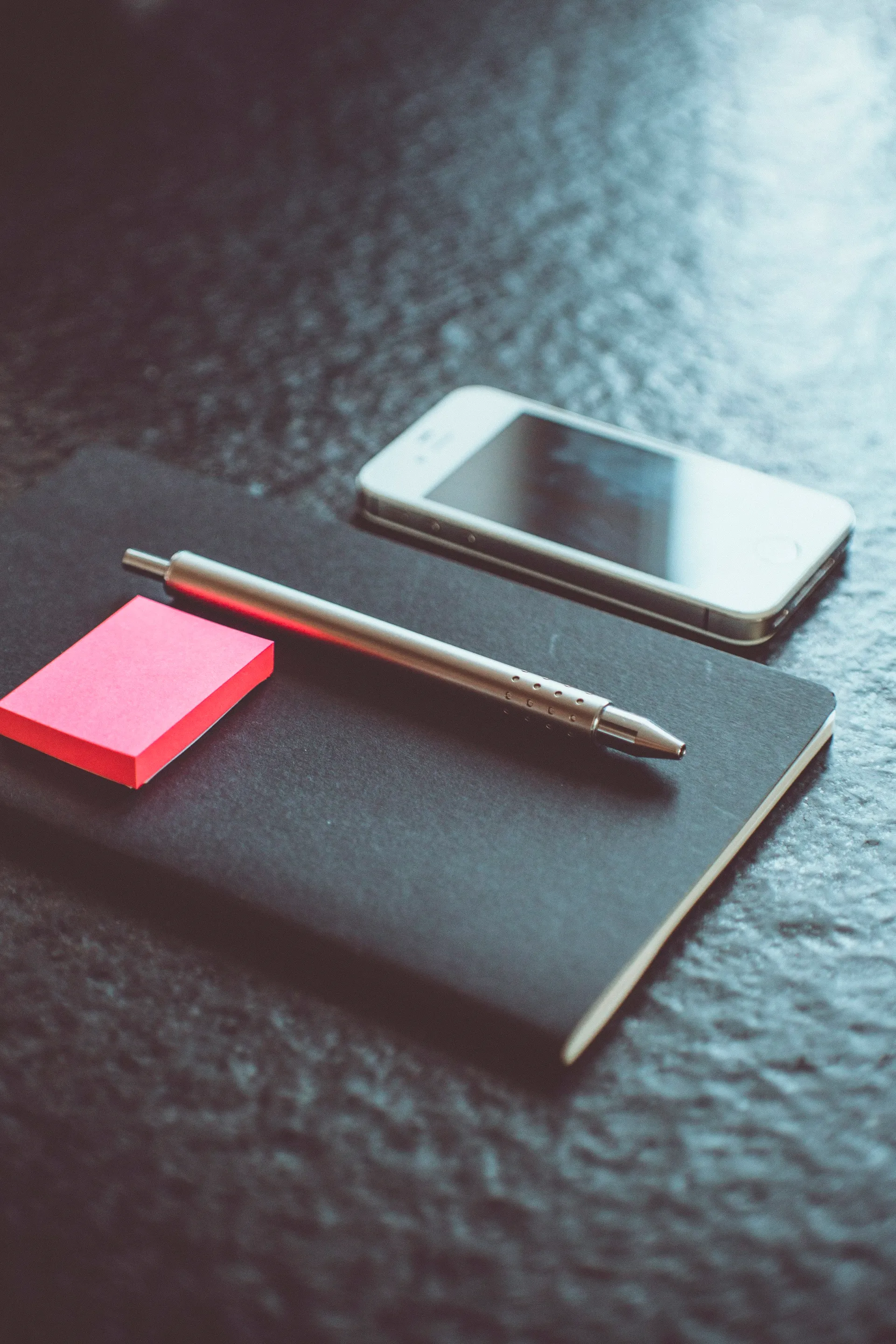 Pen on a planner beside a phone