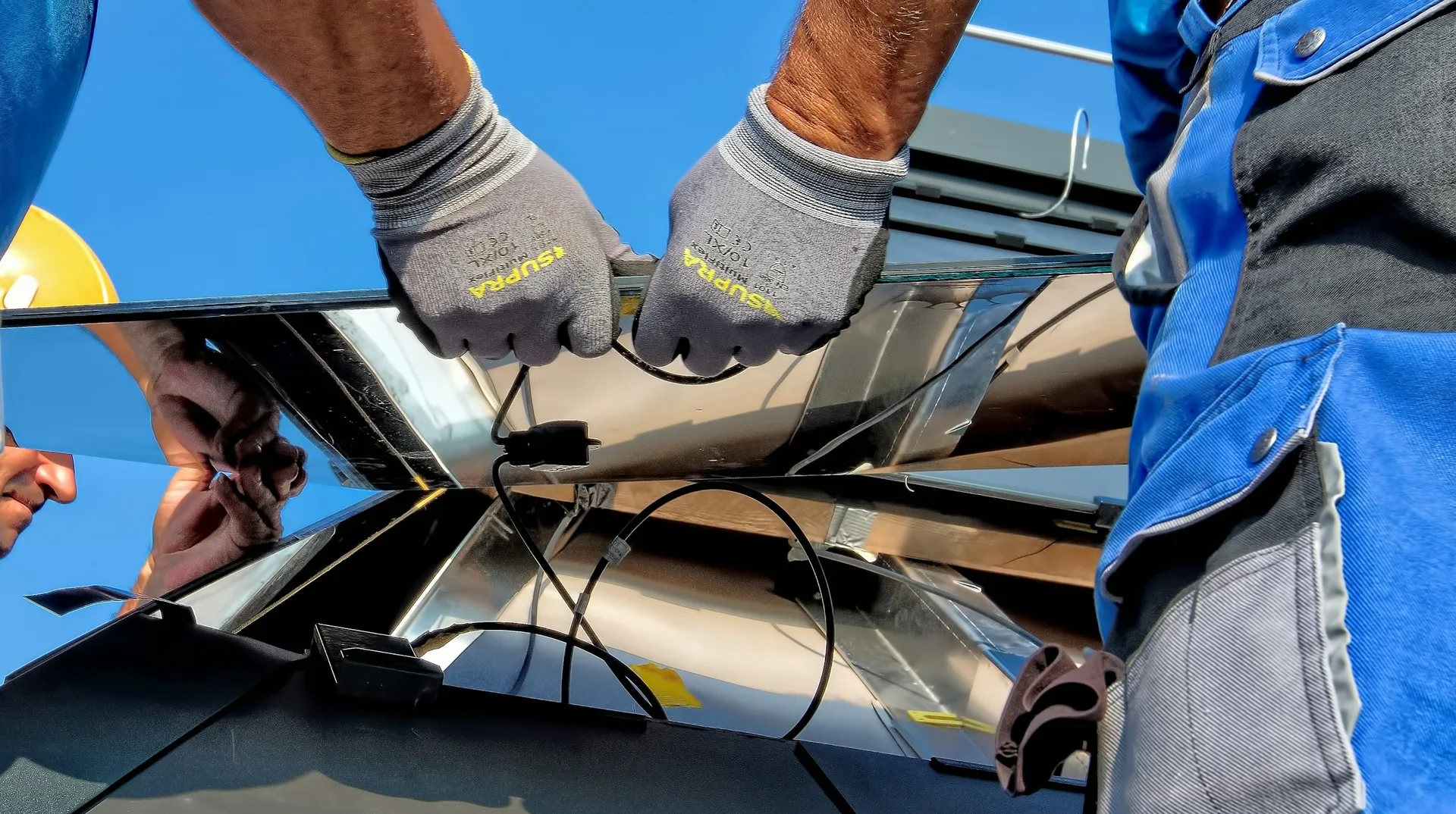 Two workers carrying a metal sheet on site